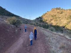 Three cold kids climbing up the dirt road