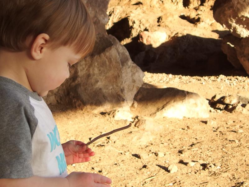Noah checking out sticks and rocks in the cave