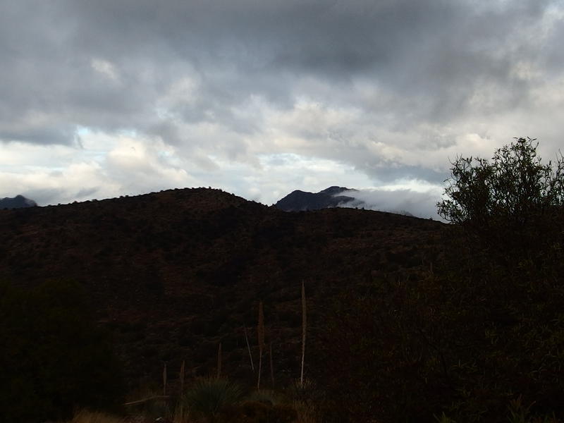 Clouds roiling from the dark mountains