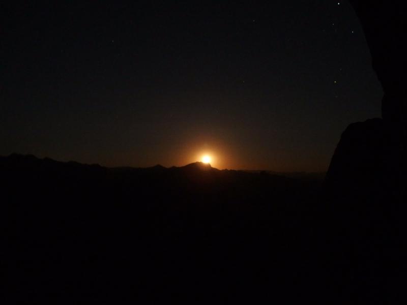 Moon slowly rising from the mountain