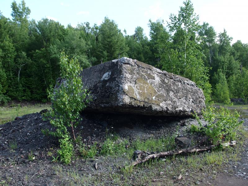 Huge cement foundation sitting on loose rock