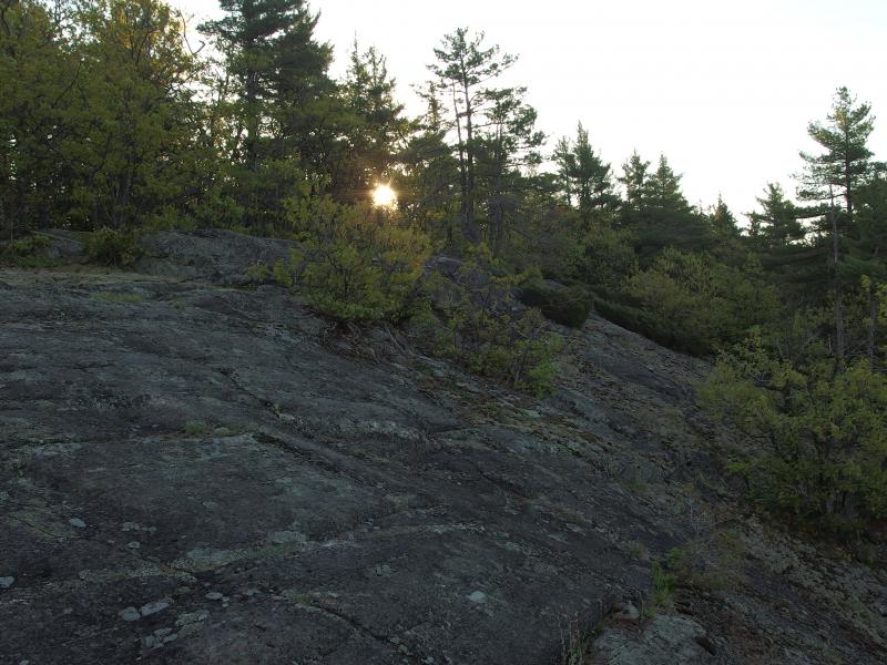 Peeking sun over the rock