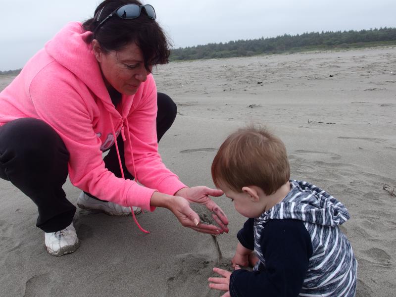 My mom showing Noah how to play with sand